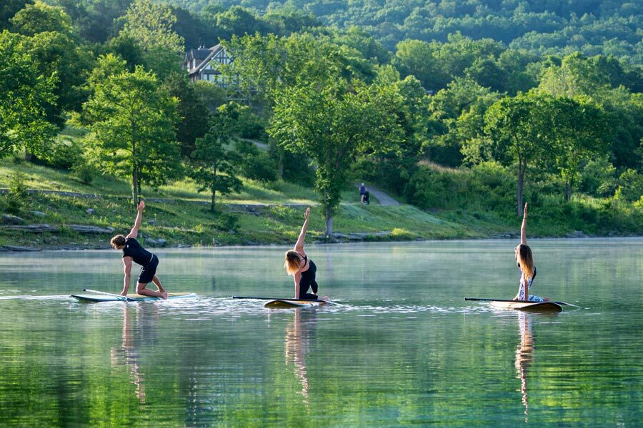 SUP Paddleboard Fitness People enjoy yoga flows on stand up paddleboards on Table Rock Lake.